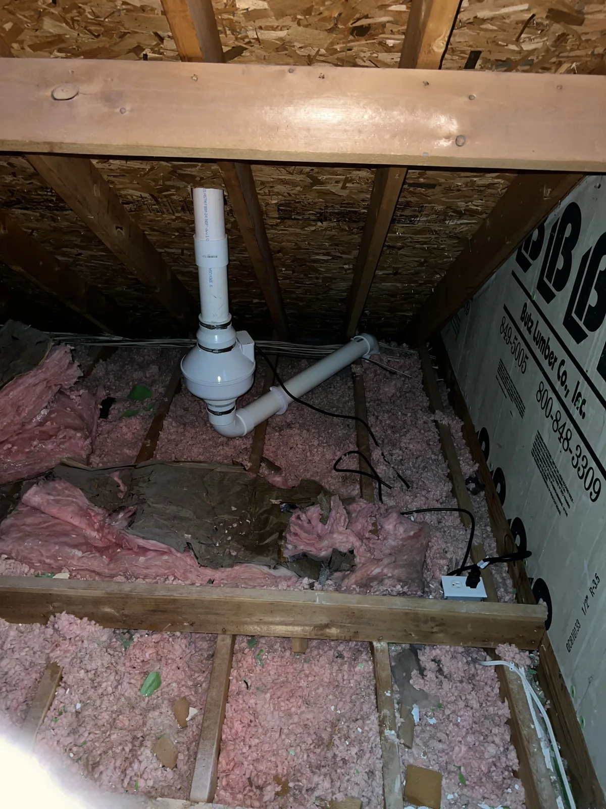 Radon fan and PVC piping installed between attic framing